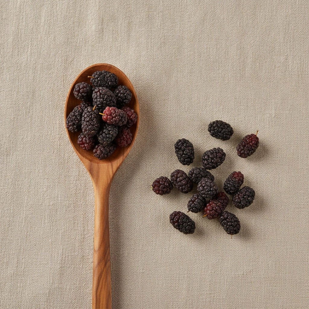 Black Mulberries Whole (Morus Nigra) | Create a luxurious, photorealistic product photograph featuring the original product naturally arranged in an elegant handcrafted wooden spoon on a soft, finely
