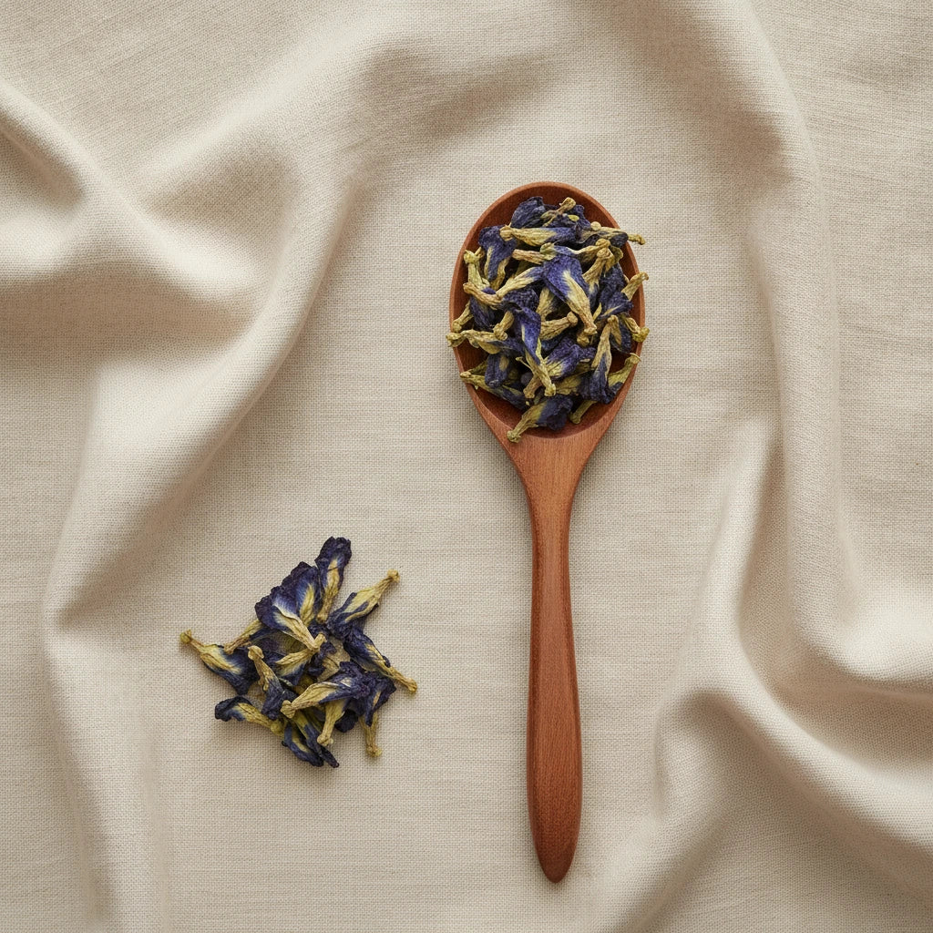 Butterfly Pea Flower Whole (Clitoria Ternatea) | Create a luxurious, photorealistic product photograph featuring the original product naturally arranged in an elegant handcrafted wooden spoon on a soft, finely