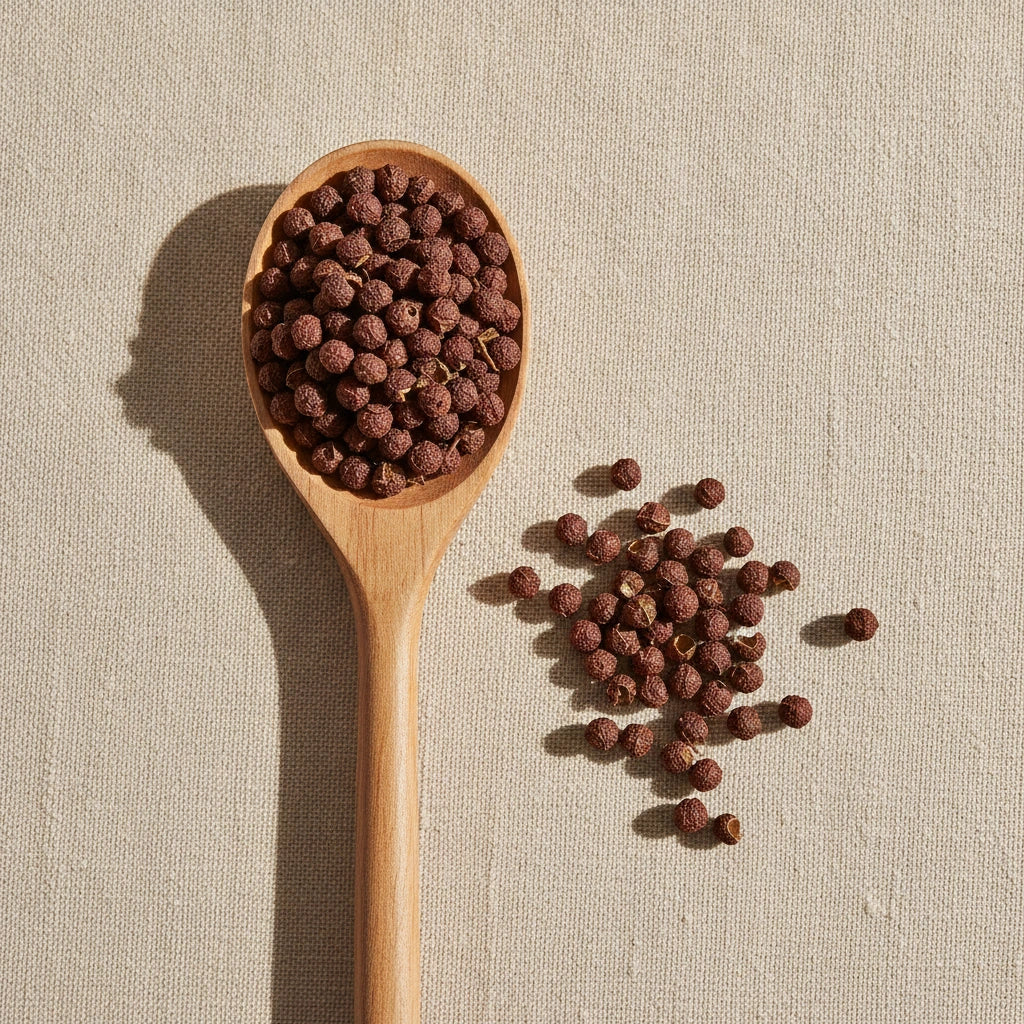 Prickly Ash Berries Whole (Zanthoxylum Clava-Herulis) | Create a luxurious, photorealistic product photograph featuring the original product naturally arranged in an elegant handcrafted wooden spoon on a soft, finely