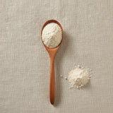 5-HTP Powder (5-Hydroxytryptophan) | Create a luxurious, photorealistic product photograph featuring the original product naturally arranged in an elegant handcrafted wooden spoon on a soft, finely
