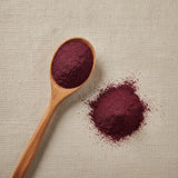 Acai Berry Powder (Euterpe Oleracea) | Create a luxurious, photorealistic product photograph featuring the original product naturally arranged in an elegant handcrafted wooden spoon on a soft, finely