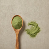 Alfalfa Leaf Powder (Medicago Sativa) | Create a luxurious, photorealistic product photograph featuring the original product naturally arranged in an elegant handcrafted wooden spoon on a soft, finely