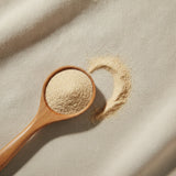 American Ginseng Powder (Panax Quinquefolius) | Create a luxurious, photorealistic product photograph featuring the original product naturally arranged in an elegant handcrafted wooden spoon on a soft, finely