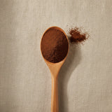Ancho Chili Powder (Capsicum Annuum) | Create a luxurious, photorealistic product photograph featuring the original product naturally arranged in an elegant handcrafted wooden spoon on a soft, finely