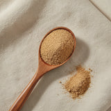 Anise Seed Powder (Pimpinella Anisum) | Create a luxurious, photorealistic product photograph featuring the original product naturally arranged in an elegant handcrafted wooden spoon on a soft, finely