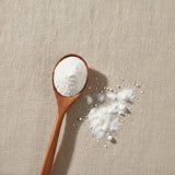 Apple Cider Vinegar Powder (Malus Domestica) | Create a luxurious, photorealistic product photograph featuring the original product naturally arranged in an elegant handcrafted wooden spoon on a soft, finely