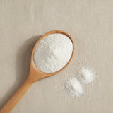 Arabic Gum Powder (Acacia Species) | Create a luxurious, photorealistic product photograph featuring the original product naturally arranged in an elegant handcrafted wooden spoon on a soft, finely