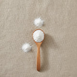 Aspartame Powder (L-Aspartyl-L-phenylalanine methyl ester) | Create a luxurious, photorealistic product photograph featuring the original product naturally arranged in an elegant handcrafted wooden spoon on a soft, finely