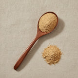 Benzoin Gum Powder (Styrax benzoin) | Create a luxurious, photorealistic product photograph featuring the original product naturally arranged in an elegant handcrafted wooden spoon on a soft, finely