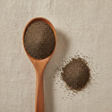 Black Peppercorn Fine Ground 30 Mesh (Piper Nigrum) | Create a luxurious, photorealistic product photograph featuring the original product naturally arranged in an elegant handcrafted wooden spoon on a soft, finely