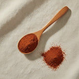 Bloodroot Powder (Sanguinaria Canadensis) | Create a luxurious, photorealistic product photograph featuring the original product naturally arranged in an elegant handcrafted wooden spoon on a soft, finely