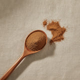 Buckthorn Bark Powder (Rhamnus Frangula) | Create a luxurious, photorealistic product photograph featuring the original product naturally arranged in an elegant handcrafted wooden spoon on a soft, finely