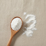Calcined Clam Shell Powder (Cyclina Sinensis) | Create a luxurious, photorealistic product photograph featuring the original product naturally arranged in an elegant handcrafted wooden spoon on a soft, finely