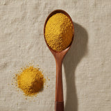 Calendula Powder (Calendula Officinalis) | Create a luxurious, photorealistic product photograph featuring the original product naturally arranged in an elegant handcrafted wooden spoon on a soft, finely