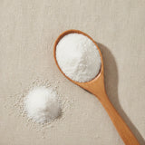 Camphor Powder (Cinnamomum Camphora) | Create a luxurious, photorealistic product photograph featuring the original product naturally arranged in an elegant handcrafted wooden spoon on a soft, finely