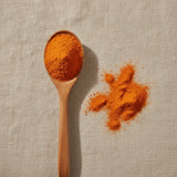 Carrot Juice Powder (Daucus Carota) | Create a luxurious, photorealistic product photograph featuring the original product naturally arranged in an elegant handcrafted wooden spoon on a soft, finely