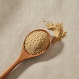 Cascara Sagrada Bark Powder (Rhamnus Purshiana) | Create a luxurious, photorealistic product photograph featuring the original product naturally arranged in an elegant handcrafted wooden spoon on a soft, finely
