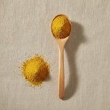 Cattail Pollen Powder (Typha Spp.) | Create a luxurious, photorealistic product photograph featuring the original product naturally arranged in an elegant handcrafted wooden spoon on a soft, finely