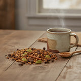 Chai Tea | Can you show this tea outside of the bag and bowl, on a table next to a hot tea cup in a rustic home.