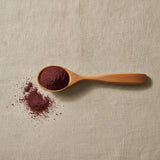 Chaste Berry Powder (Vitex Agnus-Castus) | Create a luxurious, photorealistic product photograph featuring the original product naturally arranged in an elegant handcrafted wooden spoon on a soft, finely