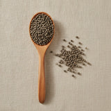 Chaste Tree Berries Whole (Vitex Agnus-Castus) | Create a luxurious, photorealistic product photograph featuring the original product naturally arranged in an elegant handcrafted wooden spoon on a soft, finely
