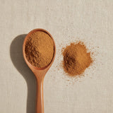 Cinchona Bark Powder (Cinchona Officinalis) | Create a luxurious, photorealistic product photograph featuring the original product naturally arranged in an elegant handcrafted wooden spoon on a soft, finely