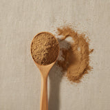 Cinnamon Powder (Cinnamomum Cassia) | Create a luxurious, photorealistic product photograph featuring the original product naturally arranged in an elegant handcrafted wooden spoon on a soft, finely