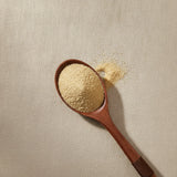 Cleanse Herbal Blend | Create a luxurious, photorealistic product photograph featuring the original product naturally arranged in an elegant handcrafted wooden spoon on a soft, finely