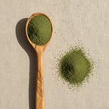 Cleavers Herb Powder (Galium Aparine) | Create a luxurious, photorealistic product photograph featuring the original product naturally arranged in an elegant handcrafted wooden spoon on a soft, finely