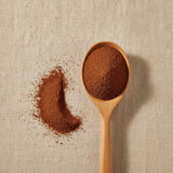 Cloves Powder (Syzygium Aromaticum) | Create a luxurious, photorealistic product photograph featuring the original product naturally arranged in an elegant handcrafted wooden spoon on a soft, finely