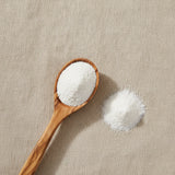 Cream of Tartar Powder (Potassium Bitartrate) | Create a luxurious, photorealistic product photograph featuring the original product naturally arranged in an elegant handcrafted wooden spoon on a soft, finely