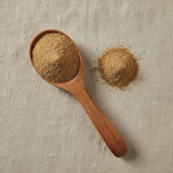 Cumin Seed Powder (Cuminum Cyminum) | Create a luxurious, photorealistic product photograph featuring the original product naturally arranged in an elegant handcrafted wooden spoon on a soft, finely
