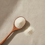 Cuttlefish Bone Powder (Sepia Esculenta) | Create a luxurious, photorealistic product photograph featuring the original product naturally arranged in an elegant handcrafted wooden spoon on a soft, finely