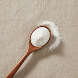 Glucosamine Sulfate Powder (Glucosamine Sulfate/Potassium) | Create a luxurious, photorealistic product photograph featuring the original product naturally arranged in an elegant handcrafted wooden spoon on a soft, finely