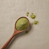 Gotu Kola Powder (Centella Asiatica) | Create a luxurious, photorealistic product photograph featuring the original product naturally arranged in an elegant handcrafted wooden spoon on a soft, finely