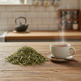 Green Tea Cut (Camillia Sinensis) | Can you show this tea outside of the bag and bowl, on a table next to a hot tea cup in a rustic home.