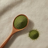 Gymnema Powder (Gymnema Sylvestre) | Create a luxurious, photorealistic product photograph featuring the original product naturally arranged in an elegant handcrafted wooden spoon on a soft, finely