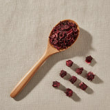 Hibiscus Flowers Whole (Hibiscus Sabdariffa) | Create a luxurious, photorealistic product photograph featuring the original product naturally arranged in an elegant handcrafted wooden spoon on a soft, finely