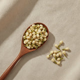 Jasmine Flowers Whole (Jasminum Officinale) | Create a luxurious, photorealistic product photograph featuring the original product naturally arranged in an elegant handcrafted wooden spoon on a soft, finely