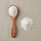 Kaolin Clay Powder (Kaolinite) | Create a luxurious, photorealistic product photograph featuring the original product naturally arranged in an elegant handcrafted wooden spoon on a soft, finely