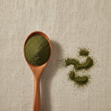 Kelp Powder (Ascophyllum Nodosum) | Create a luxurious, photorealistic product photograph featuring the original product naturally arranged in an elegant handcrafted wooden spoon on a soft, finely