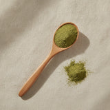 Lemon Balm Powder (Melissa Officinalis) | Create a luxurious, photorealistic product photograph featuring the original product naturally arranged in an elegant handcrafted wooden spoon on a soft, finely