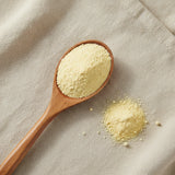Lime Juice Powder (Citrus × Latifolia) | Create a luxurious, photorealistic product photograph featuring the original product naturally arranged in an elegant handcrafted wooden spoon on a soft, finely