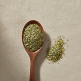 Linden Leaf & Flower Cut (Tilia Vulgaris) | Create a luxurious, photorealistic product photograph featuring the original product naturally arranged in an elegant handcrafted wooden spoon on a soft, finely