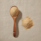 Lion's Mane Mushroom Powder (Hericium Erinaceus) | Create a luxurious, photorealistic product photograph featuring the original product naturally arranged in an elegant handcrafted wooden spoon on a soft, finely