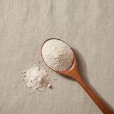 Lychee Juice Powder (Litchi Chinensis) | Create a luxurious, photorealistic product photograph featuring the original product naturally arranged in an elegant handcrafted wooden spoon on a soft, finely