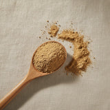 Maca Root Powder (Lepidium Meyenii) | Create a luxurious, photorealistic product photograph featuring the original product naturally arranged in an elegant handcrafted wooden spoon on a soft, finely
