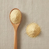 Mandarin Tangerine Juice Powder (Citrus Reticulata Blanco) | Create a luxurious, photorealistic product photograph featuring the original product naturally arranged in an elegant handcrafted wooden spoon on a soft, finely