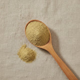 Mexican Thistle Herb Powder (Eryngium Carlinae) | Create a luxurious, photorealistic product photograph featuring the original product naturally arranged in an elegant handcrafted wooden spoon on a soft, finely