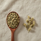 Mullein Flowers Whole (Gnaphalium Spp.) | Create a luxurious, photorealistic product photograph featuring the original product naturally arranged in an elegant handcrafted wooden spoon on a soft, finely